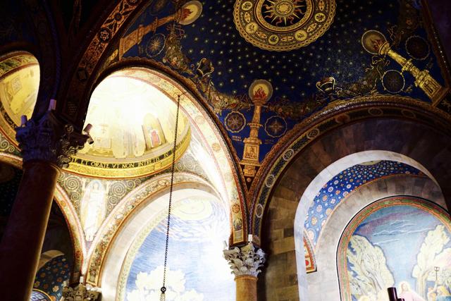 An ornate, arched ceiling with intricate frescoes and detailed patterns, featuring celestial and religious motifs